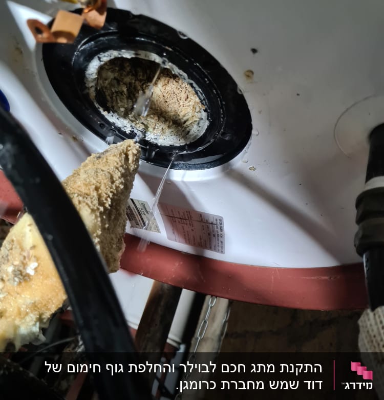 חוטי חשמל מחוברים לדוד מים עם חלודה
